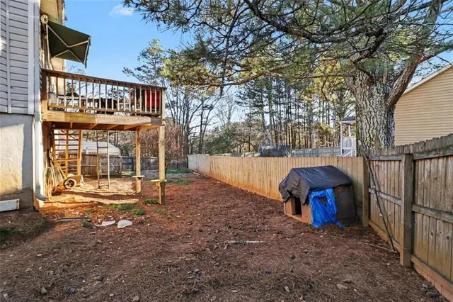 a backyard of a house with barbeque oven and wooden fence