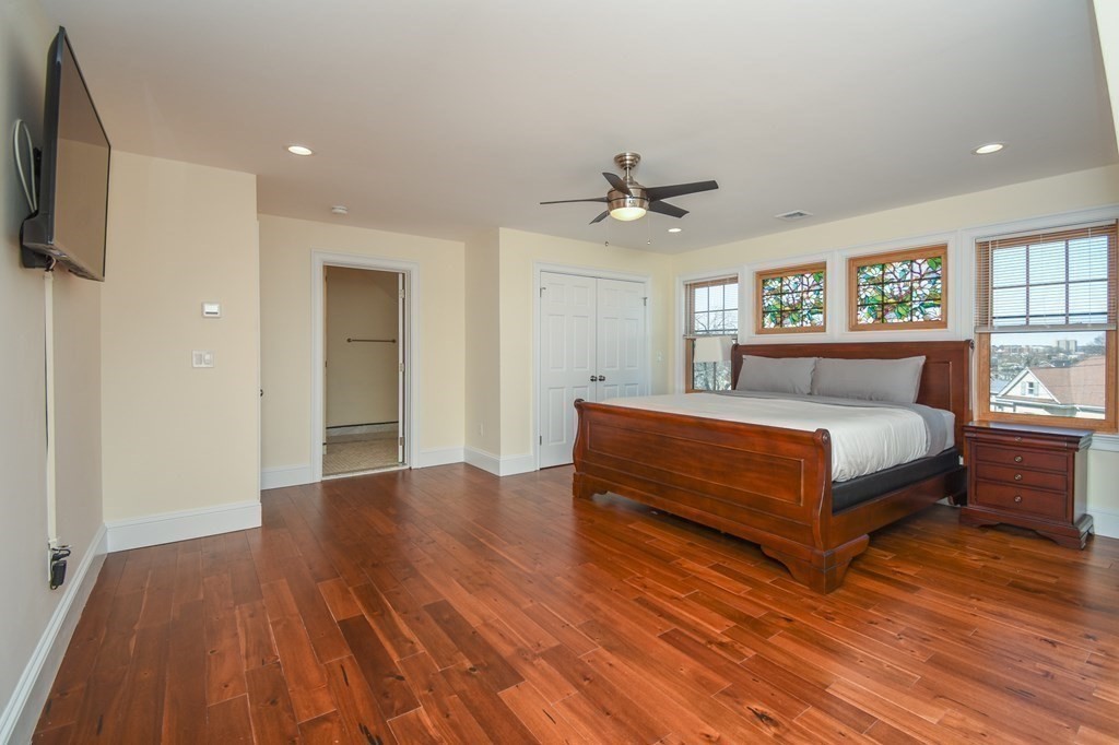 32 Cameron Street Everett, MA 02149 - Photo 11 of 22 a spacious bedroom with a bed and a flat screen tv
