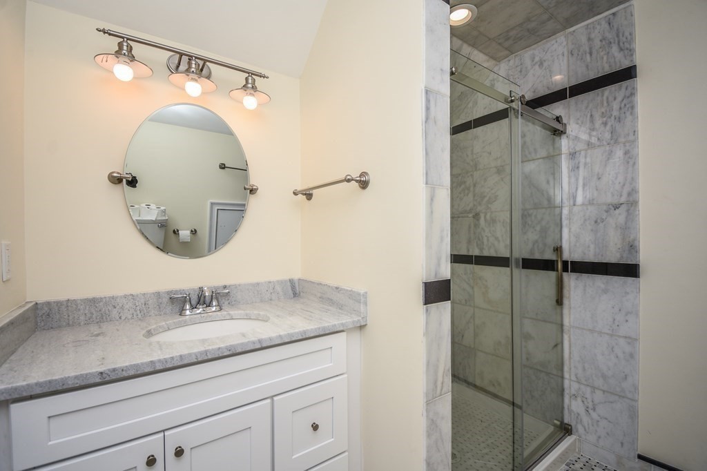 32 Cameron Street Everett, MA 02149 - Photo 16 of 22 a bathroom with a granite countertop sink a mirror and shower