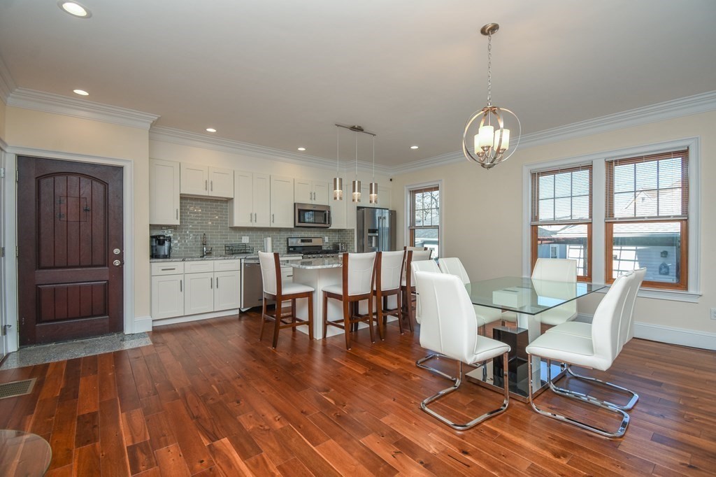 32 Cameron Street Everett, MA 02149 - Photo 3 of 22 a view of a dining room with furniture a kitchen and chandelier