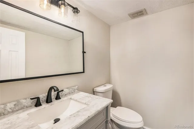 a bathroom with a sink a toilet and mirror