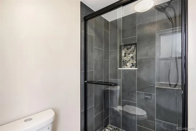 a bathroom with a toilet and a shower