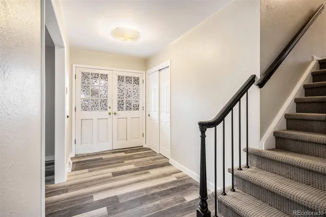 a view of a livingroom with wooden floor and stairs