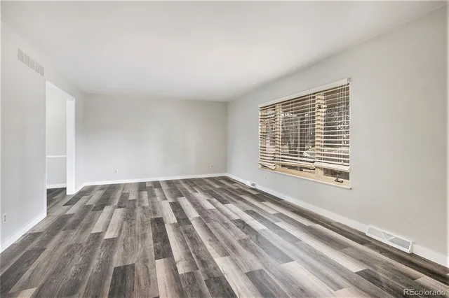 a view of a room with wooden floor and a window