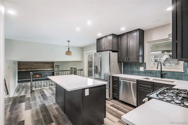 a kitchen with stainless steel appliances a stove a sink and a refrigerator