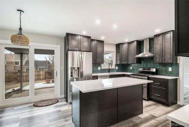 a kitchen with stainless steel appliances granite countertop a sink a stove and a refrigerator