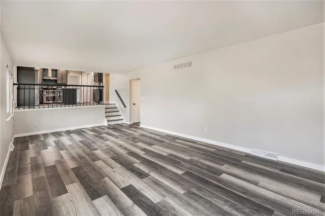 a view of empty room with wooden floor and cabinets