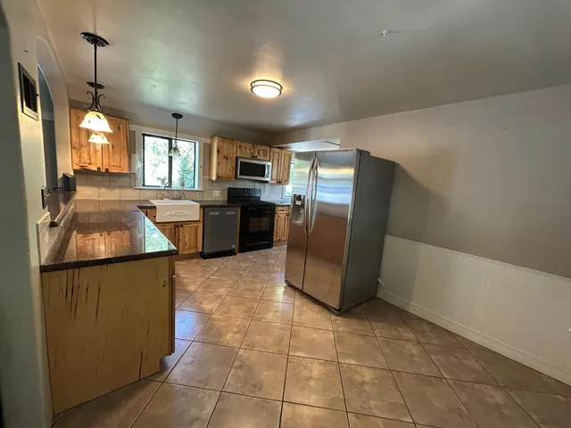 a kitchen with a refrigerator a sink dishwasher stove top oven and cabinets