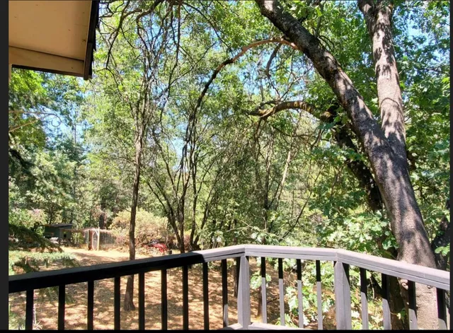 a view of a wooden balcony with trees