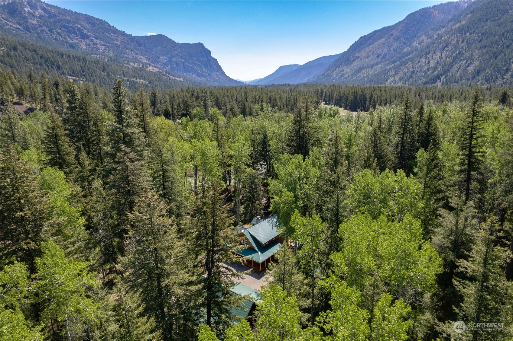 699 Lost River Road Mazama, WA 98833 - Photo 11 of 40 a view of a lush green hillside and a building