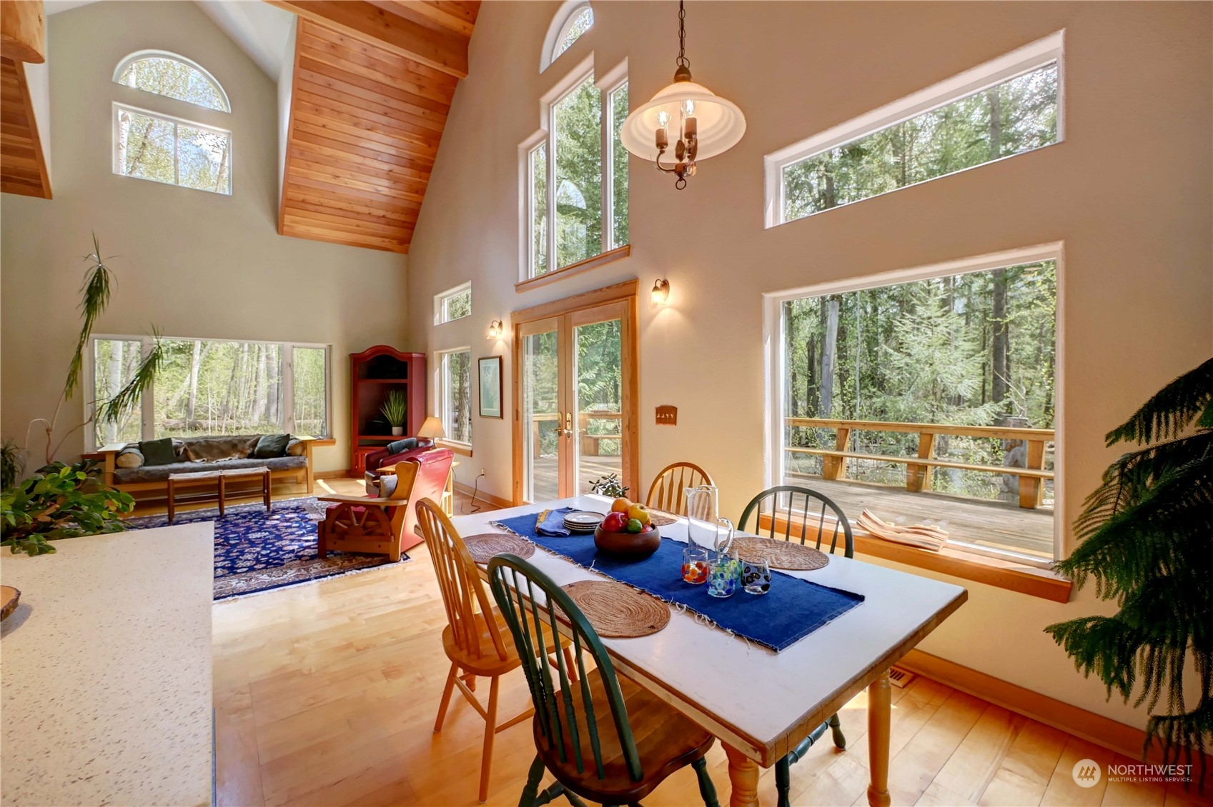 699 Lost River Road Mazama, WA 98833 - Photo 24 of 40 a view of a dining room with furniture a chandelier and large windows
