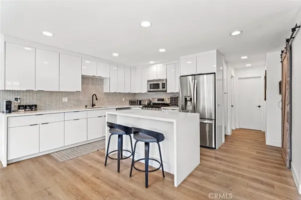 a kitchen with white cabinets and refrigerator