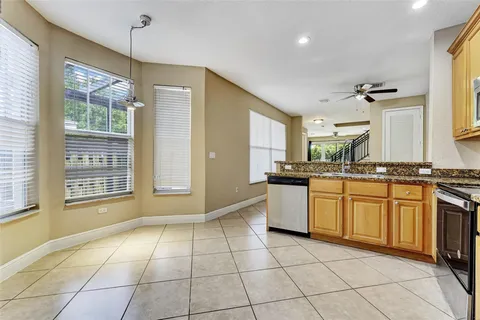 a view of an empty room with window and chandelier fan