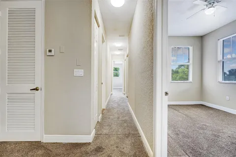 an empty room with windows and fan