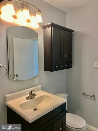 a bathroom with a sink vanity mirror and toilet