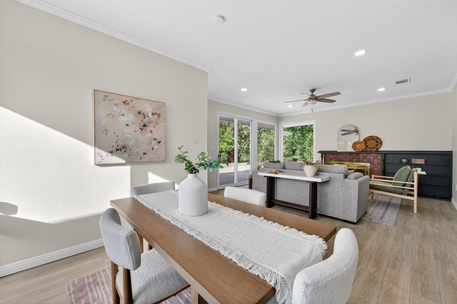 a living room with furniture a large window and wooden floor
