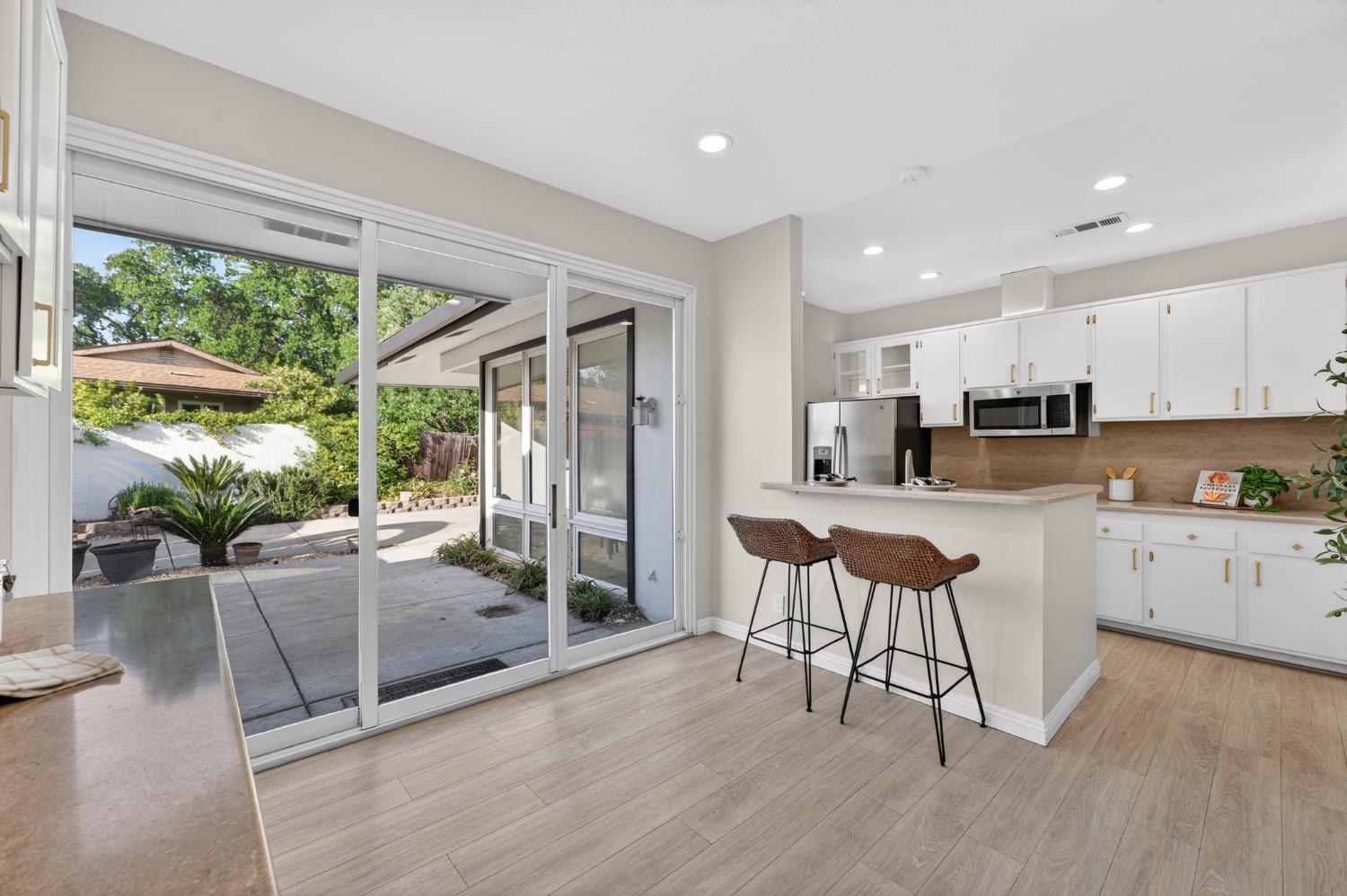6035 Bryce Way Rocklin, CA 95677 - Photo 19 of 39 a kitchen with stainless steel appliances granite countertop a stove a sink a refrigerator and white cabinets with wooden floor