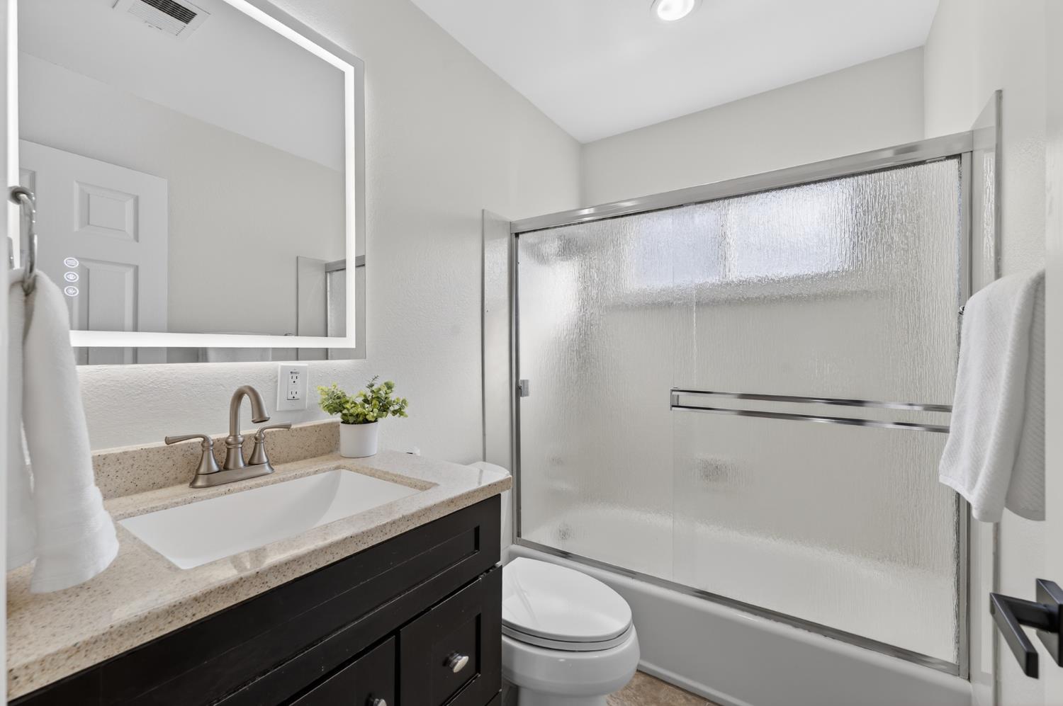 6035 Bryce Way Rocklin, CA 95677 - Photo 22 of 39 a bathroom with a granite countertop sink toilet a mirror and shower