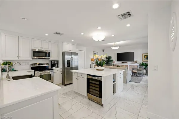 a kitchen with a sink stainless steel appliances and white cabinets