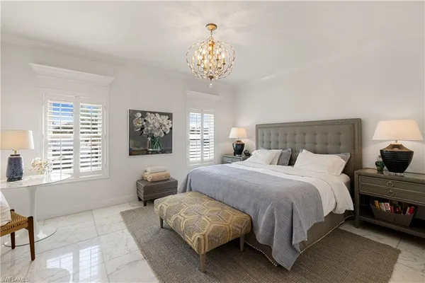 a bedroom with a large bed and a chandelier