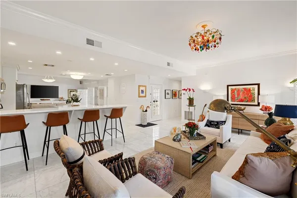 a living room with furniture kitchen view and a flat screen tv