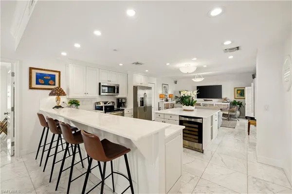a large kitchen with kitchen island a dining table and chairs
