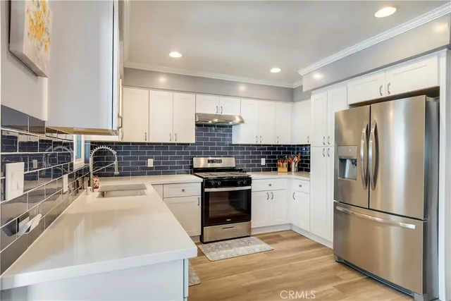 a kitchen with a refrigerator sink and white cabinets