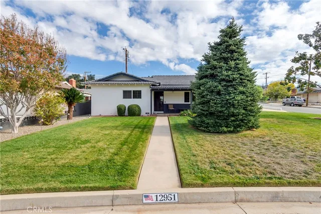a view of house in front of a yard with potted plants