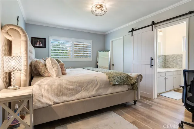 a large bed sitting in a bedroom next to a window with pc on the dresser