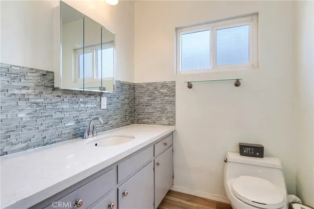 a bathroom with a sink a toilet and mirror