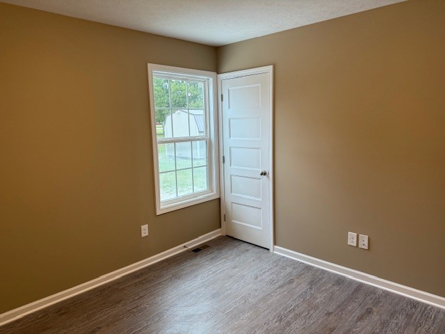 1427 Old Estill Springs Road Tullahoma, TN 37388 - Photo 17 of 44 an empty room with wooden floor and windows