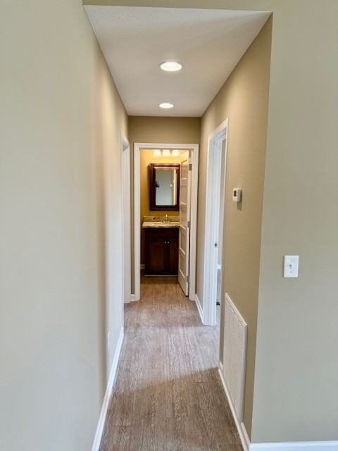 1427 Old Estill Springs Road Tullahoma, TN 37388 - Photo 37 of 44 a view of a hallway with wooden floor and a bathroom