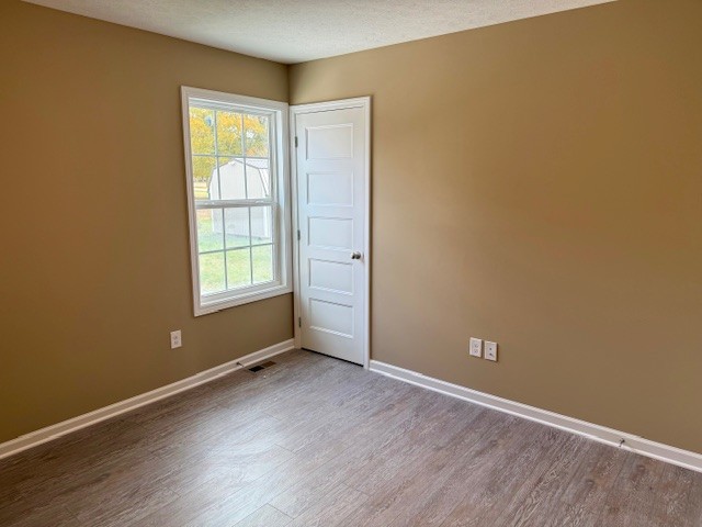 1427 Old Estill Springs Road Tullahoma, TN 37388 - Photo 41 of 44 an empty room with wooden floor and windows