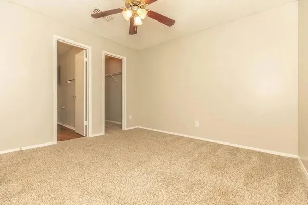 an empty room with a chandelier fan