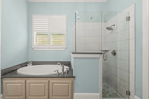a bathroom with a granite countertop sink a toilet and shower