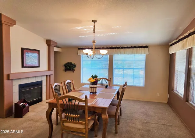 a dining room with furniture a chandelier and window