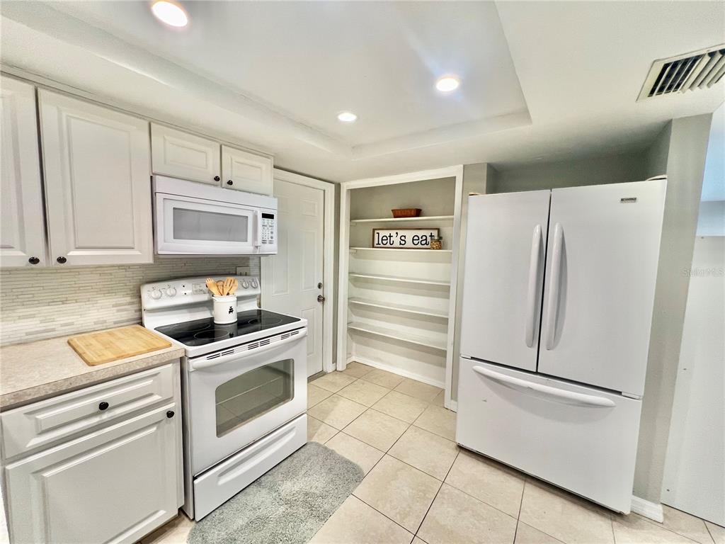 12206 Quail Run Row Hudson, FL 34667 - Photo 11 of 20 a kitchen with a refrigerator sink and cabinets