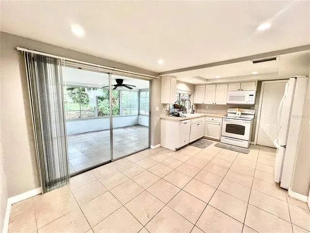a kitchen with a refrigerator a stove and white cabinets