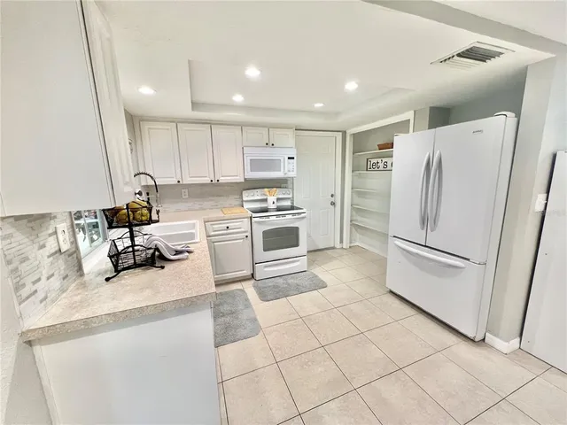 a large white kitchen with a large window