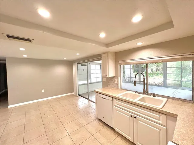 a kitchen with a refrigerator sink and cabinets