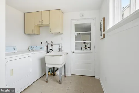 a utility room with cabinets washer and dryer