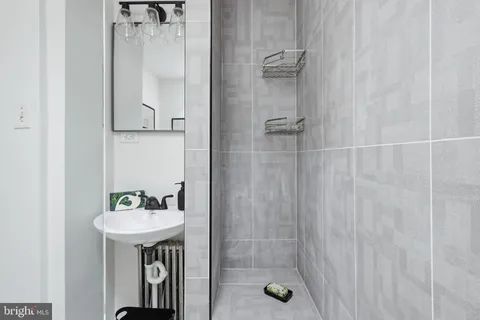 a bathroom with a sink a mirror and shower