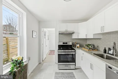 a kitchen with stainless steel appliances a stove a sink a refrigerator and cabinets