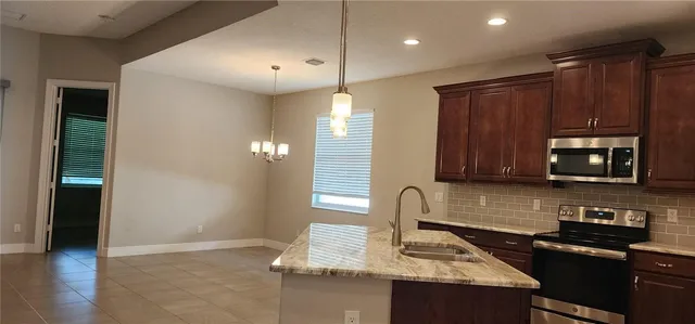 a kitchen with granite countertop cabinets stove and microwave