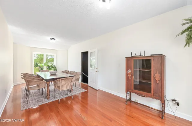 a living room with furniture a flat screen tv and a large window