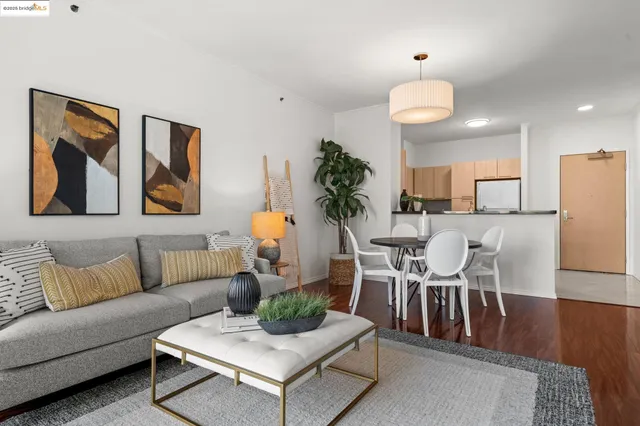 a living room with furniture kitchen and a potted plant