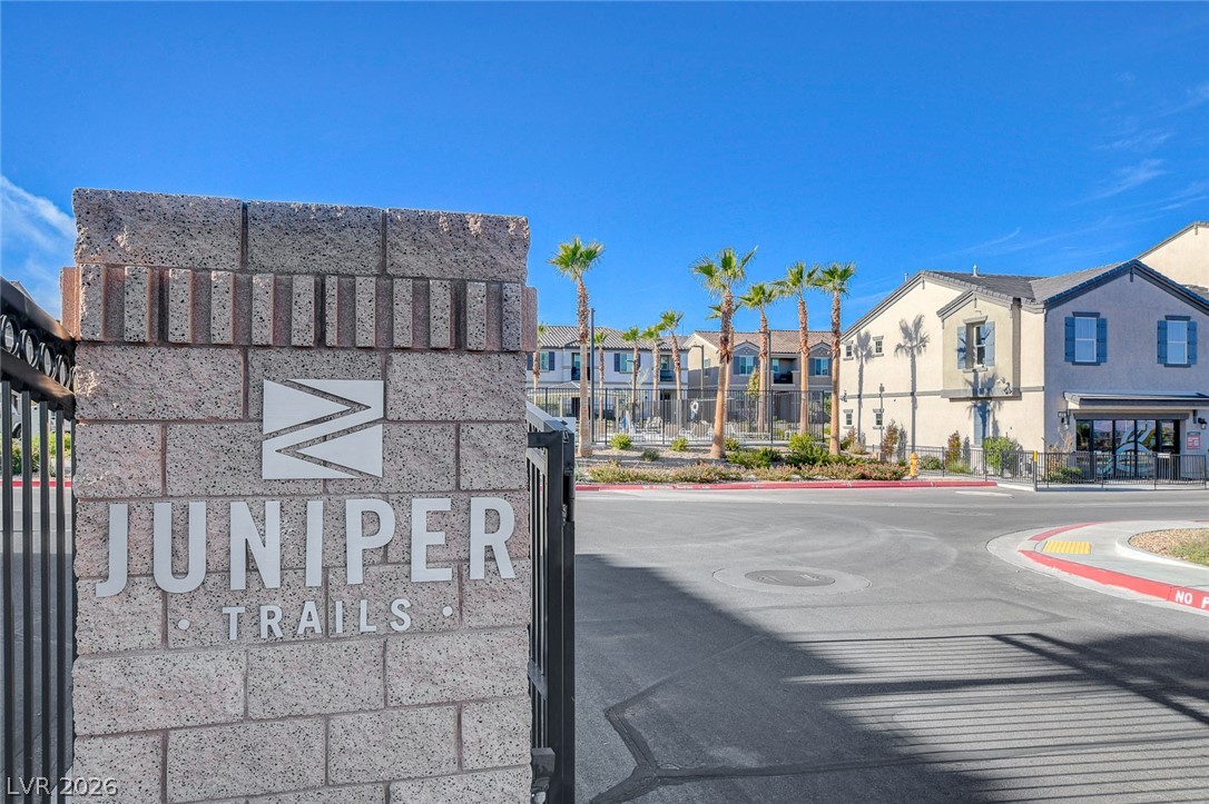 484 Filaree Place Henderson, NV 89015 - Photo 71 of 71 This community entrance welcomes residents with a stone sign and views of modern homes and palm trees.