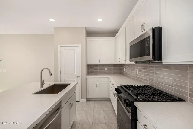 a kitchen with granite countertop a sink stainless steel appliances and cabinets
