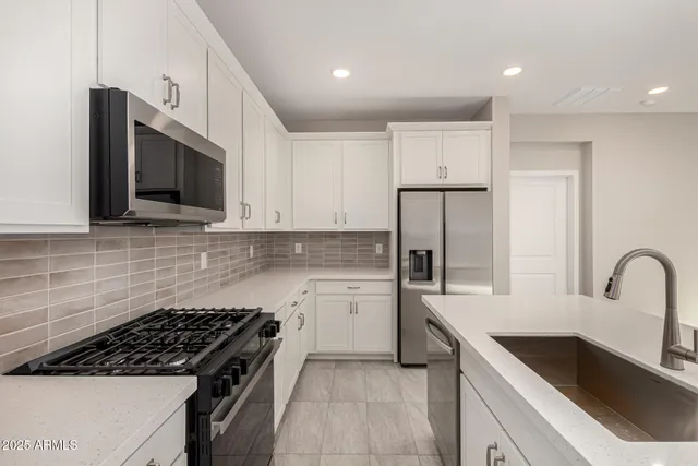 a kitchen with granite countertop a sink stainless steel appliances and cabinets