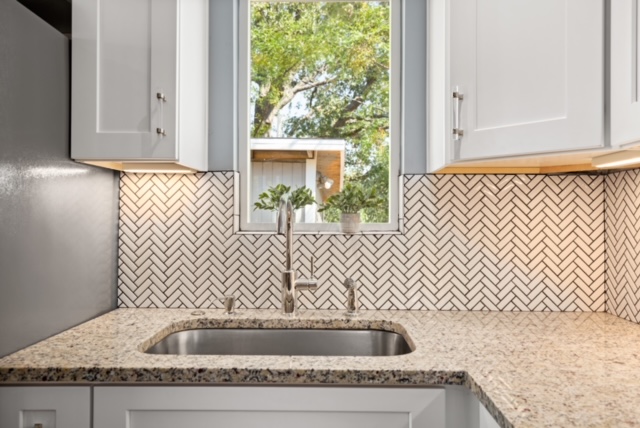 1183 Coleto Street Austin, TX 78702 - Photo 12 of 17 a bathroom with a granite countertop sink and white cabinets